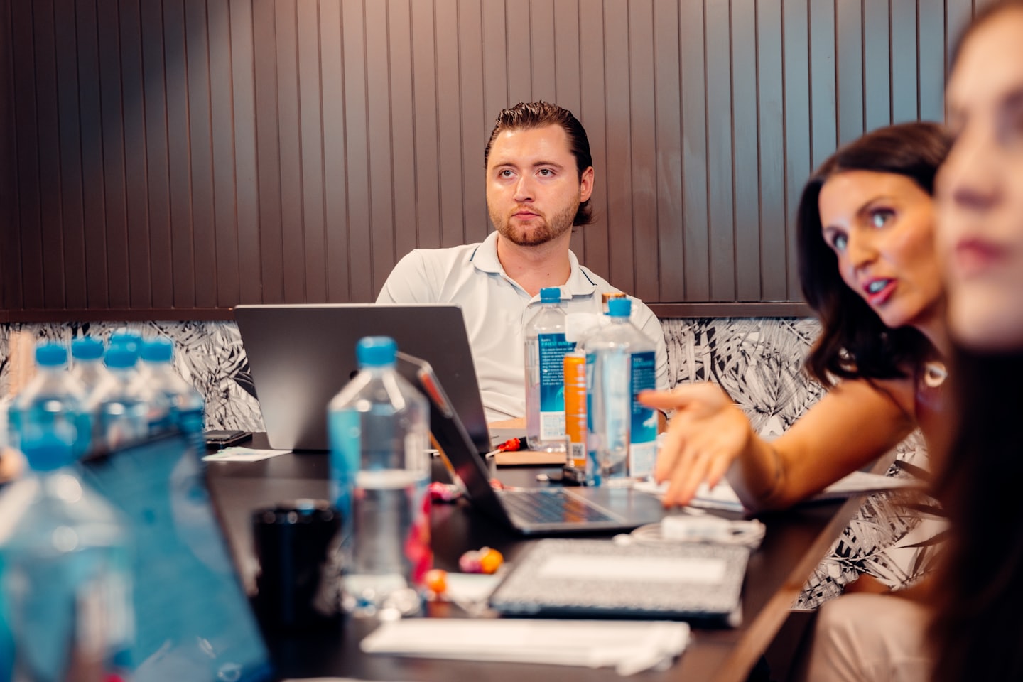 Professionals discuss work during a meeting in a conference room.